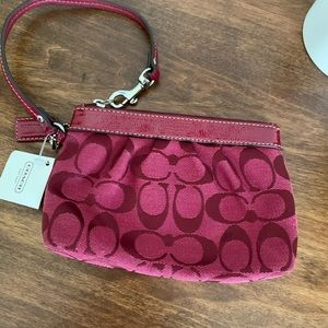 Coach wristlet burgundy with zipper and inner pocket.